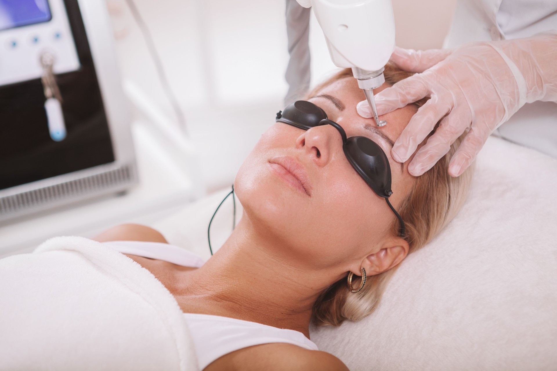 Beautiful mature woman getting facial cosmetology treatment